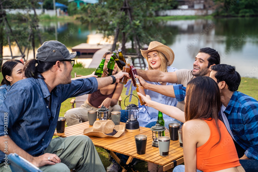 Group of diverse friend having outdoors camping party together in tent.