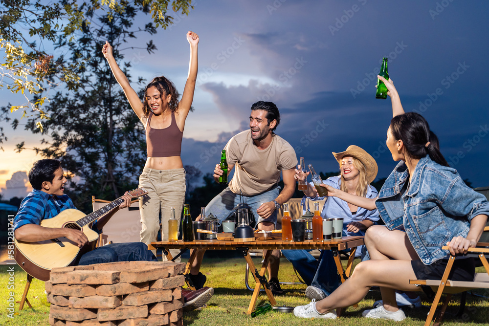 Group of diverse friend having outdoors camping party together in tent. 