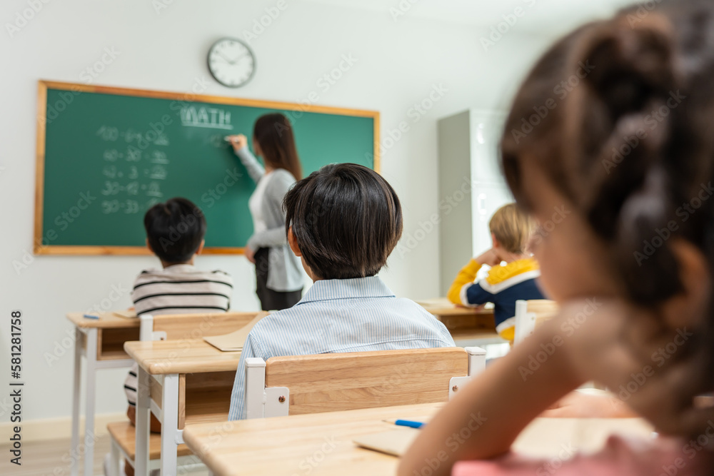 Group of student learn with teacher in classroom at elementary school. 