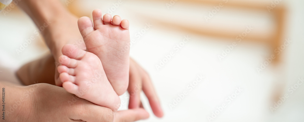 Asian Mother hands in heart shape. Baby feet in mothers hands that mean symblo of love. Mom and her