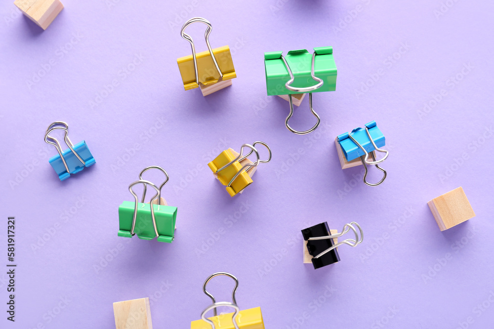 Different binder clips on color background