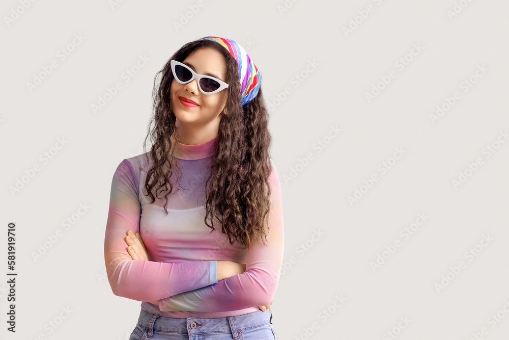 Teenage girl in stylish sunglasses on green background