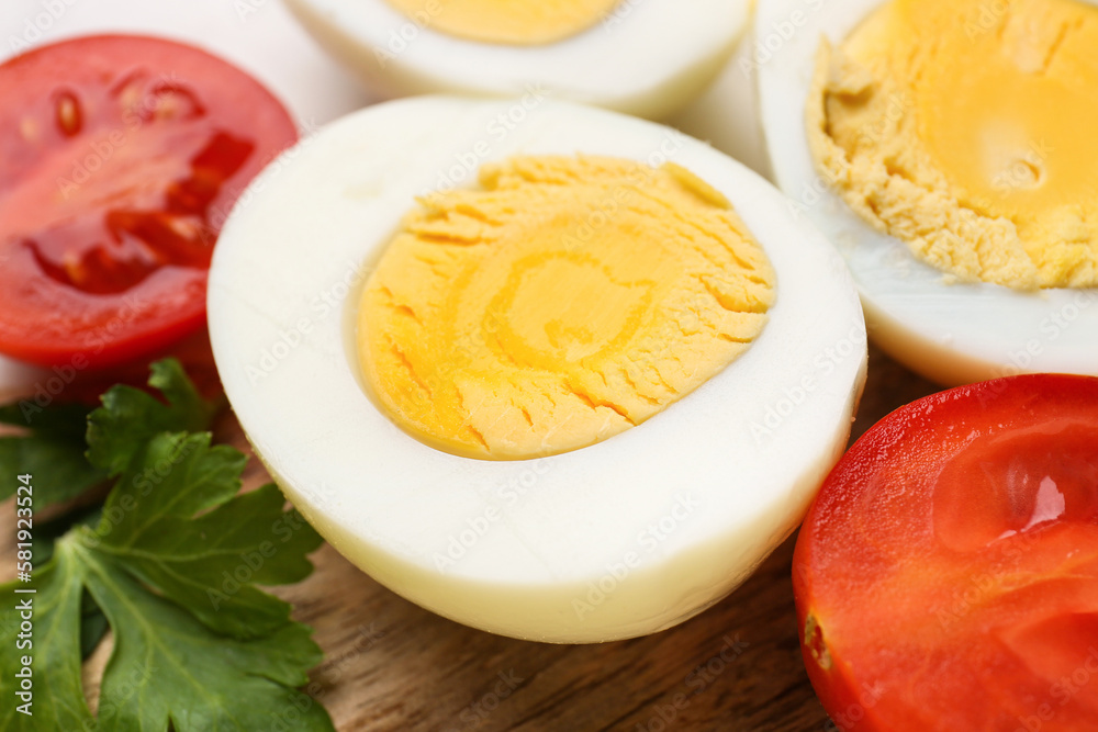 Delicious boiled eggs, tomatoes and parsley on board, closeup