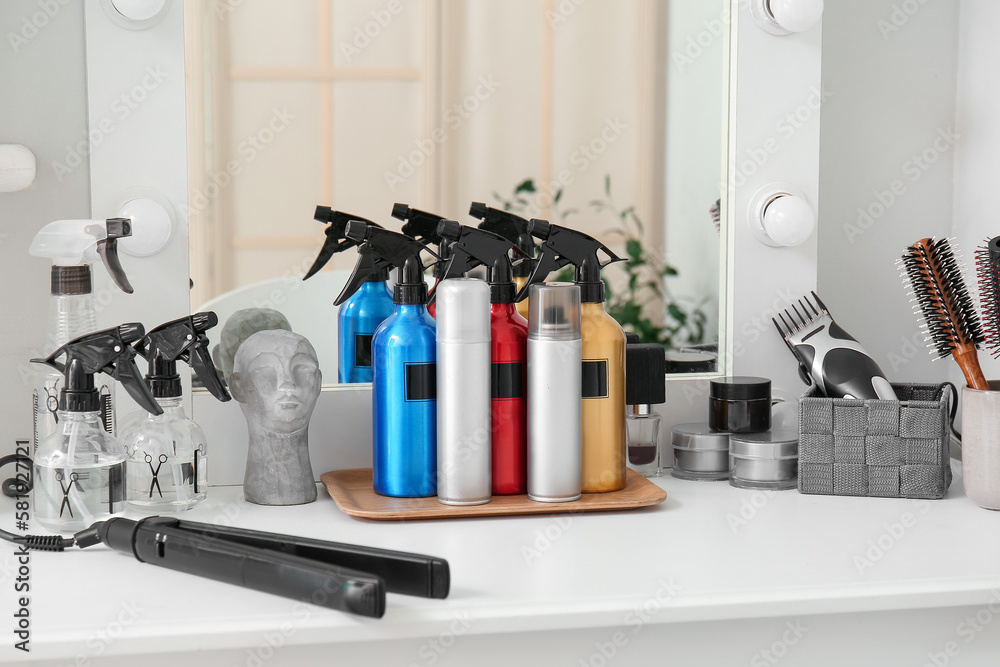 Hair sprays with accessories on table in beauty salon