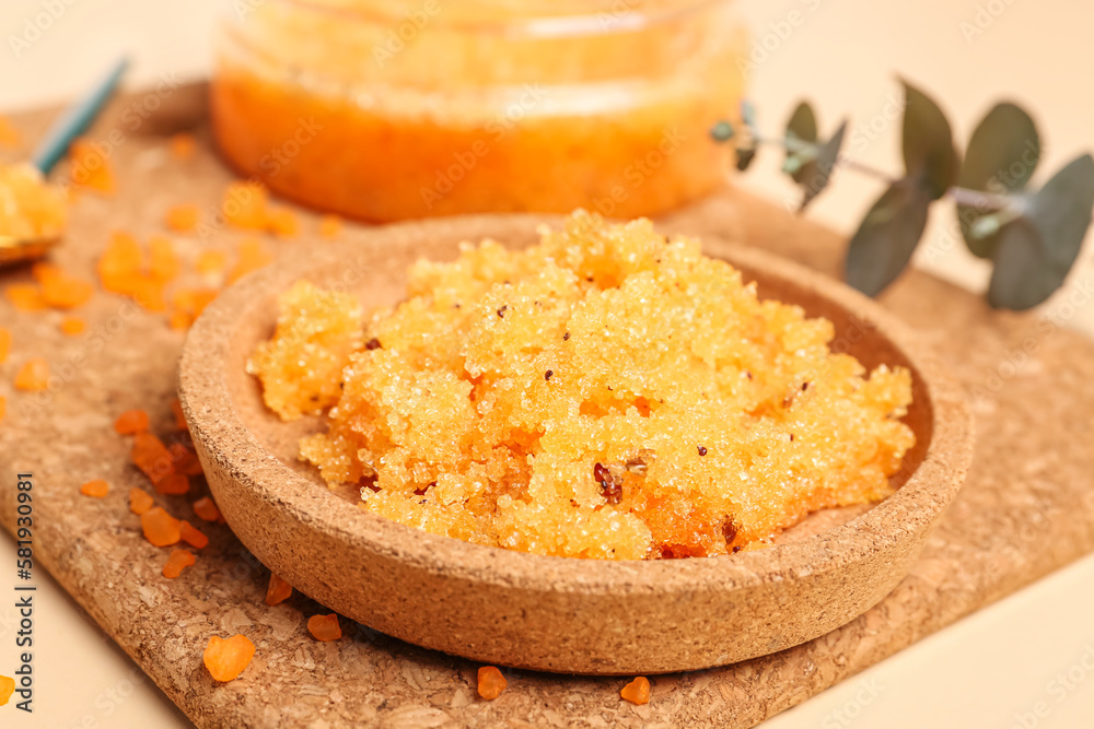 Cork mat with plate of body scrub on color background, closeup