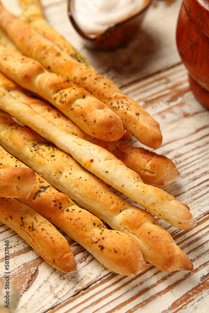 Tasty Italian Grissini on light wooden background, closeup