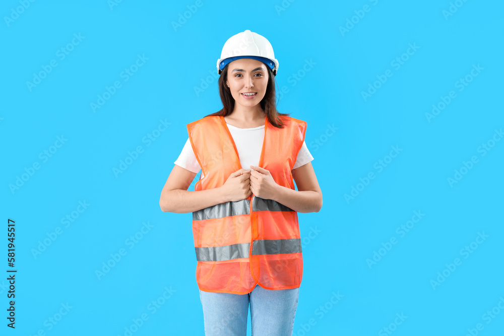 Female worker in vest on blue background