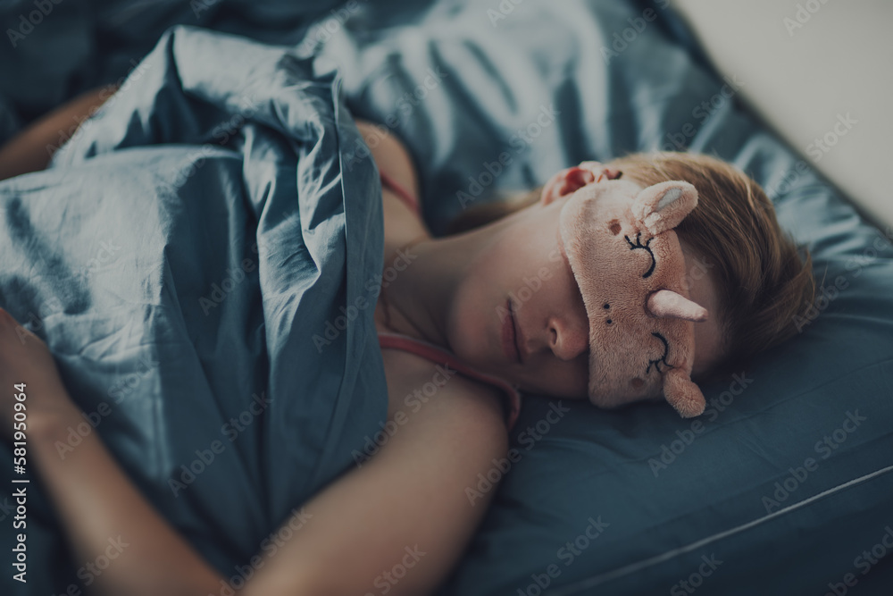 Young woman in sleep mask in bed portrait