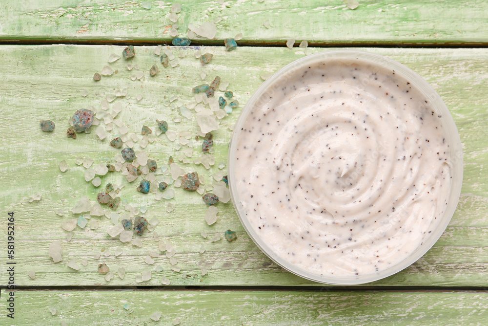 Jar of body scrub and sea salt on color wooden background