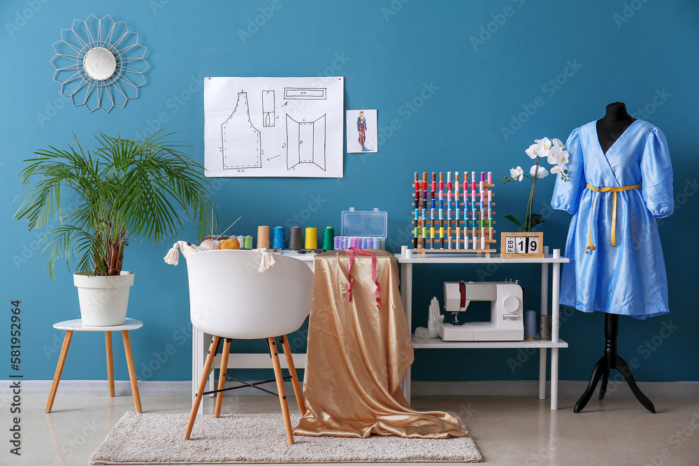 Interior of atelier with tailors workplace, thread spools and mannequin