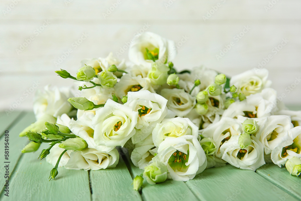 Bouquet of beautiful eustoma flowers on color wooden table, closeup