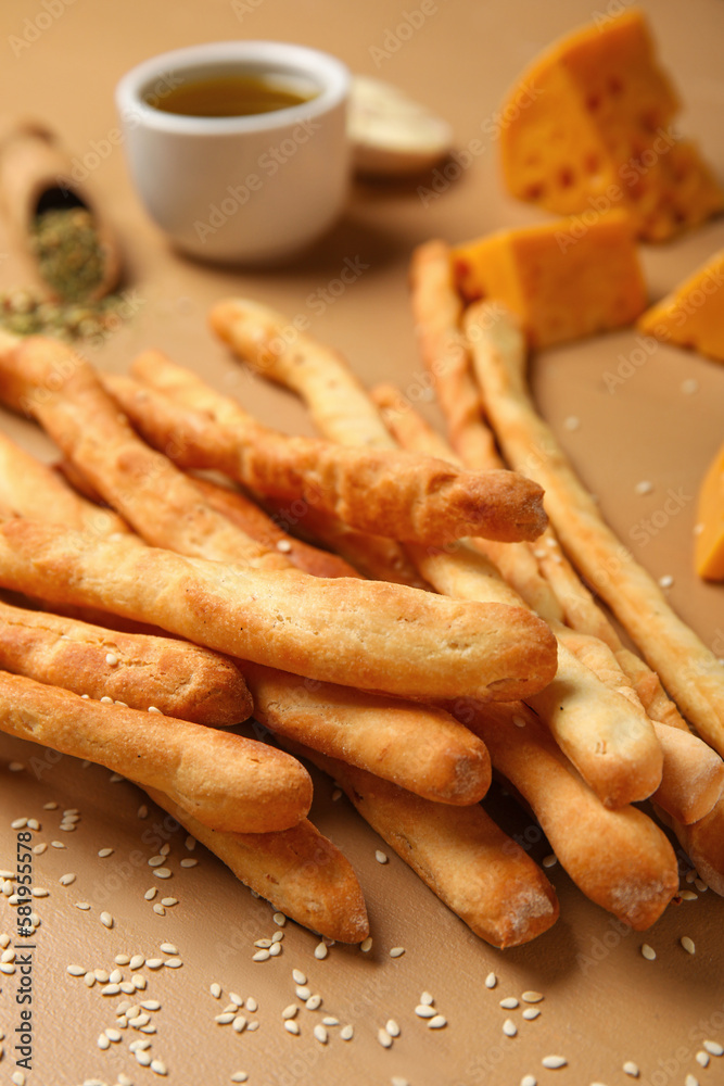 Tasty Italian Grissini on beige wooden background, closeup