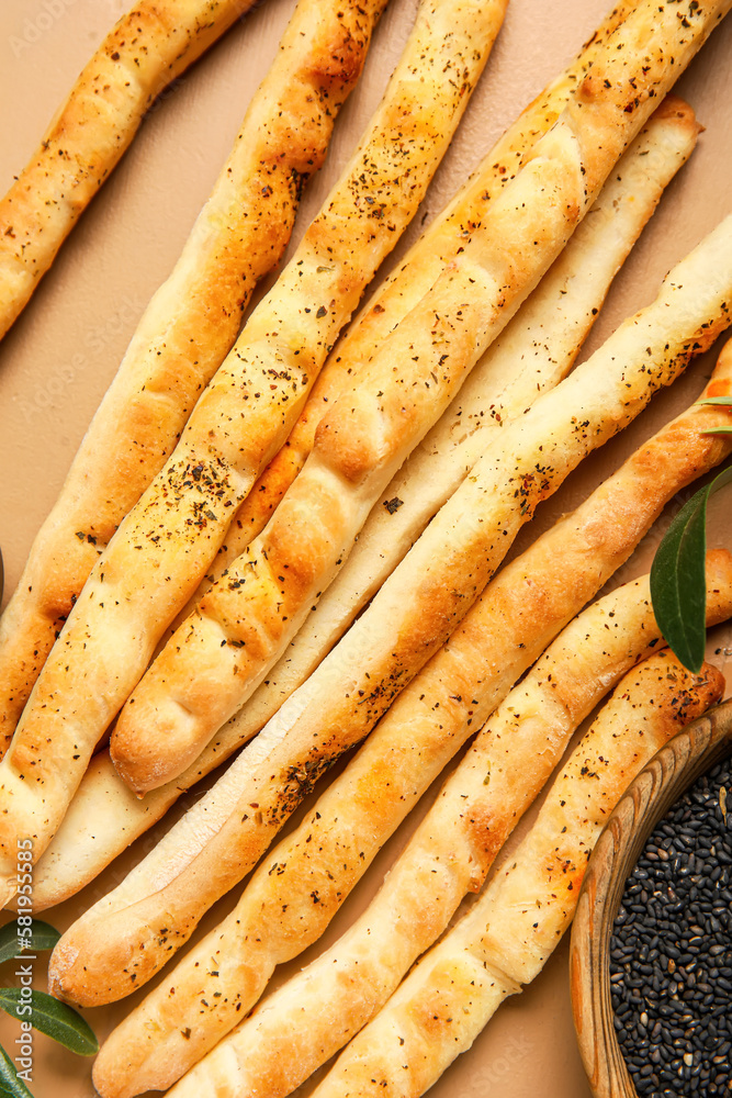 Tasty Italian Grissini on beige wooden background, closeup