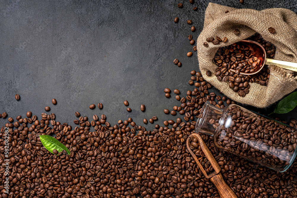 Scoop of coffee beans in a bag on dark background. Top view of coffee in a cup. Copy space for text