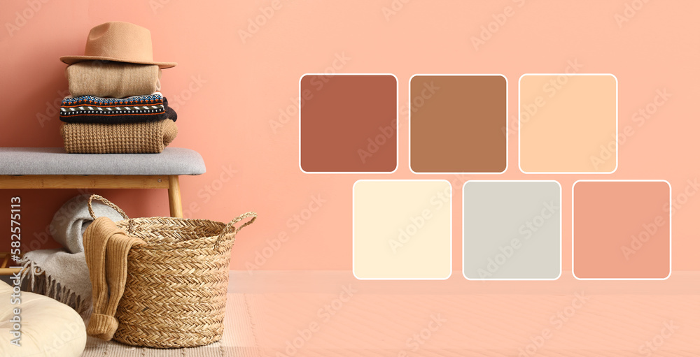 Bench with folded sweaters, felt hat and wicker basket near pink wall. Different color patterns