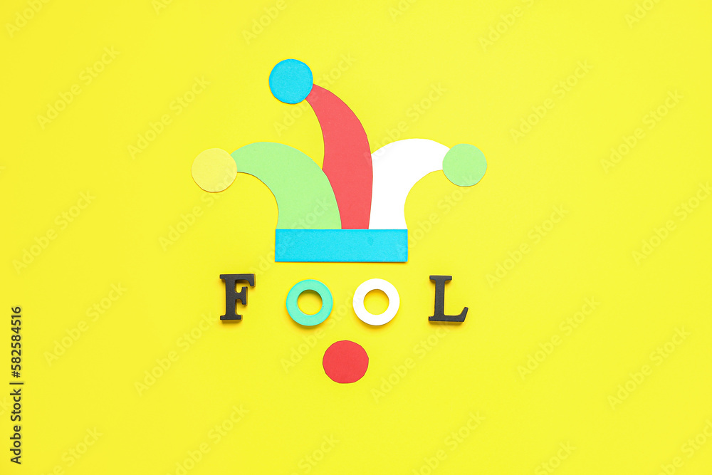 Paper hat with word FOOL on yellow background