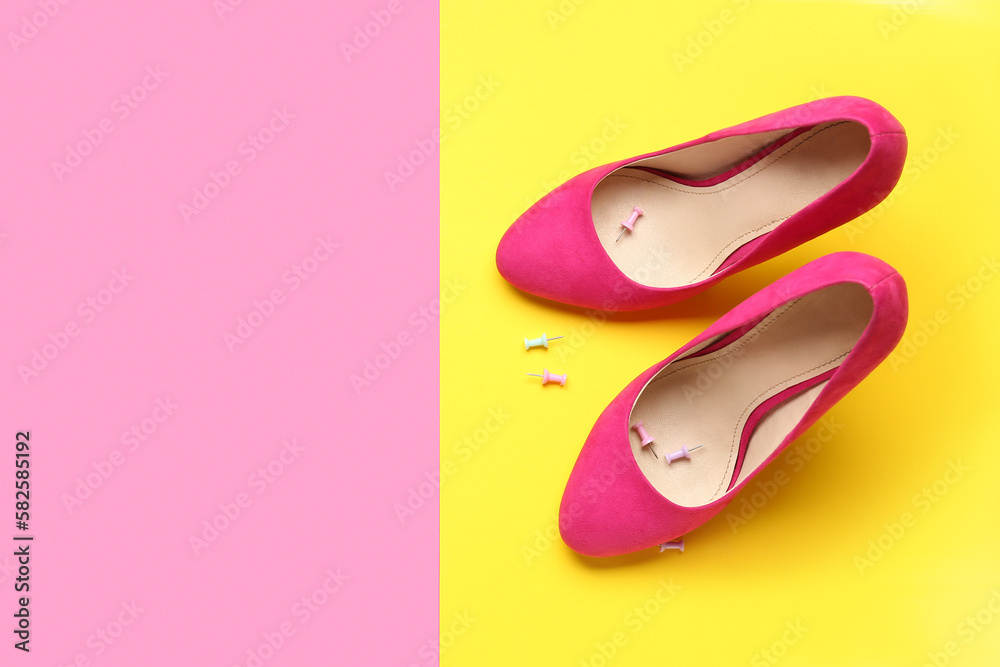 Heels with pins on color background. April Fools Day celebration