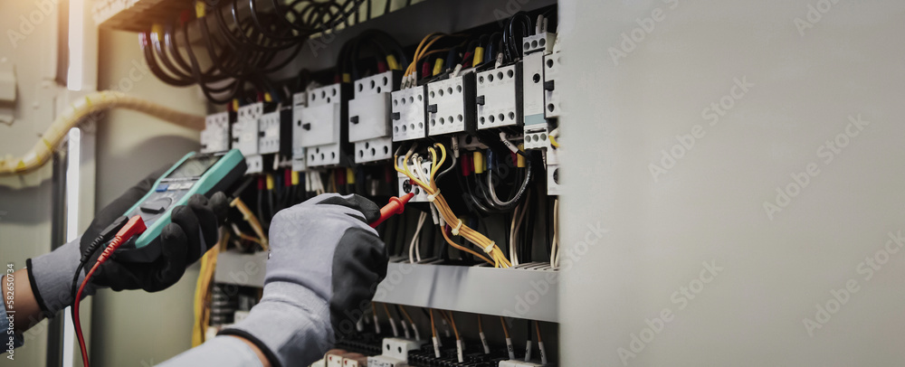 Electricity and electrical maintenance service, Engineer hand holding AC multimeter checking electri