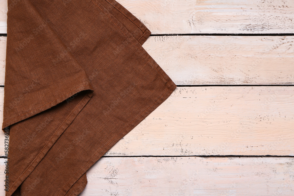 Folded napkin on light wooden background