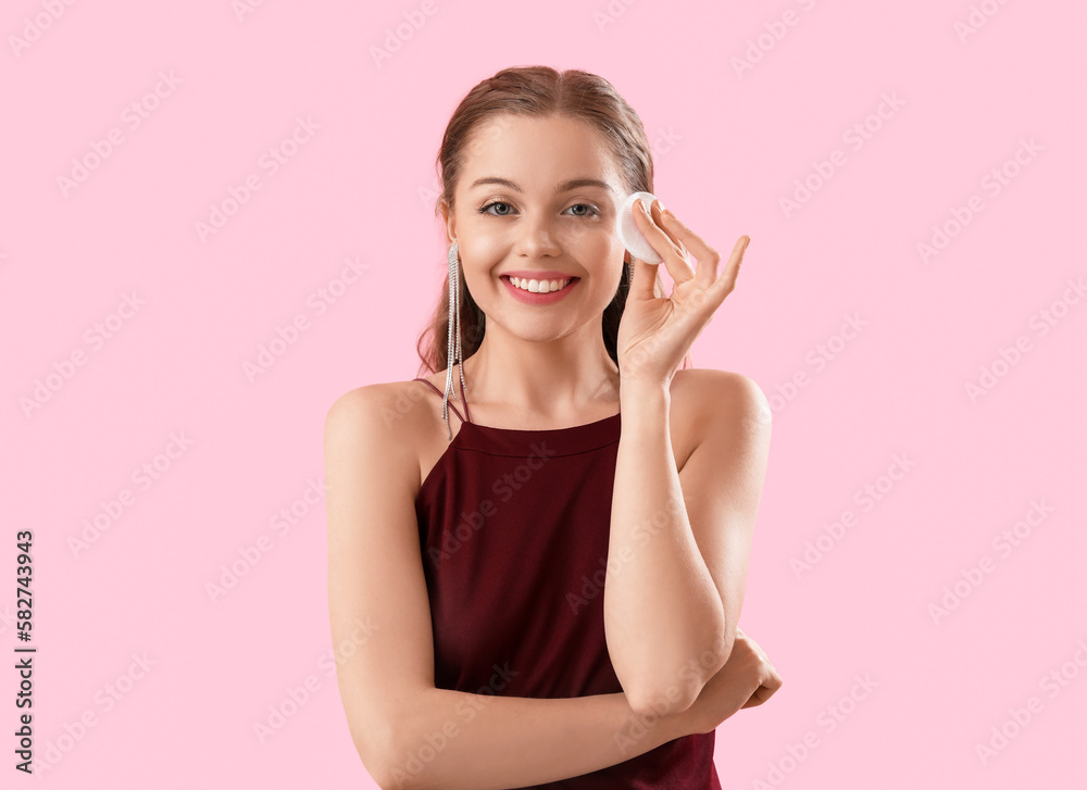 Young woman with cotton pad on pink background