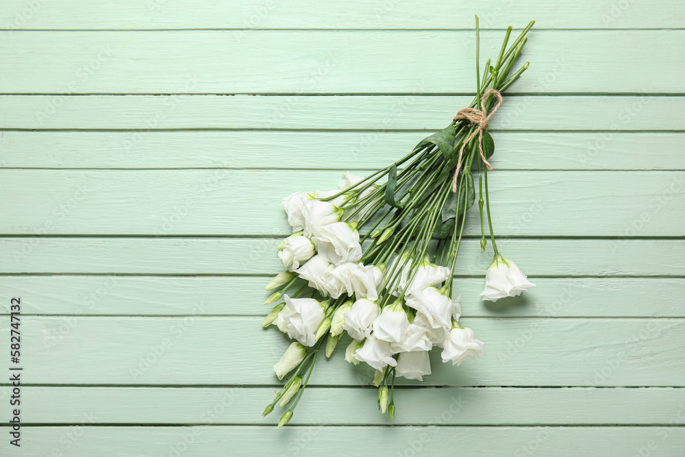 Bouquet of beautiful eustoma flowers on color wooden background