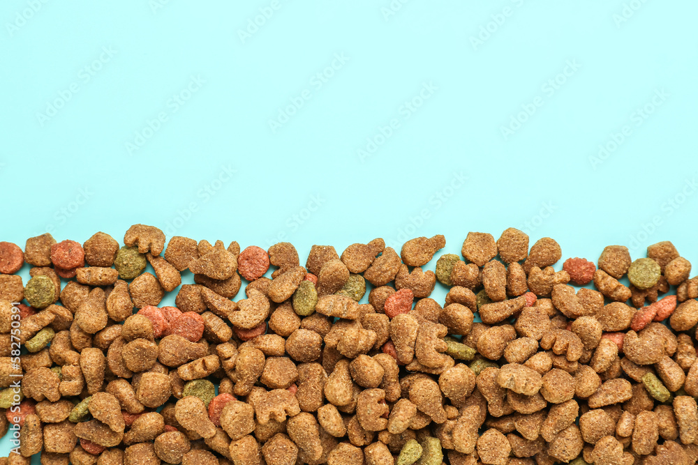 Heap of dry pet food on color background, closeup