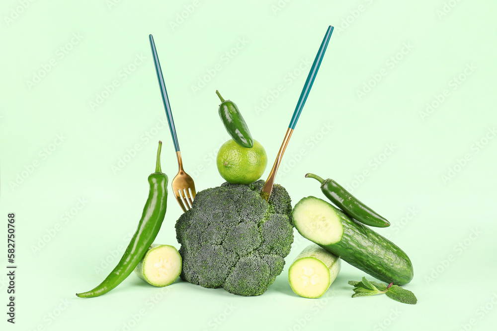 Composition with different fresh green vegetables on color background