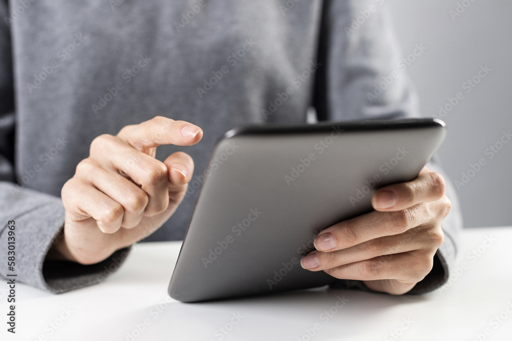 Close-up of female hands touching screen of tablet