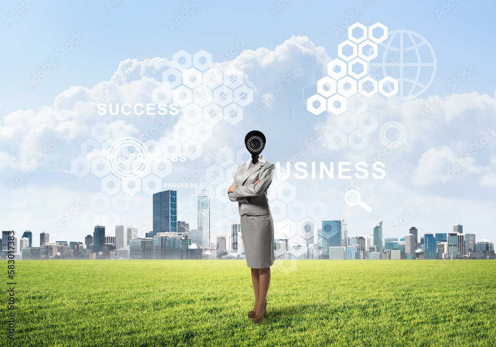 Camera headed woman standing on green grass against modern cityscape