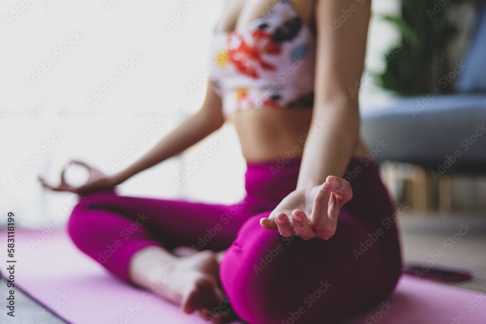 Beautiful asian woman doing relaxing exercise at home and practicing yoga in quiet living room.