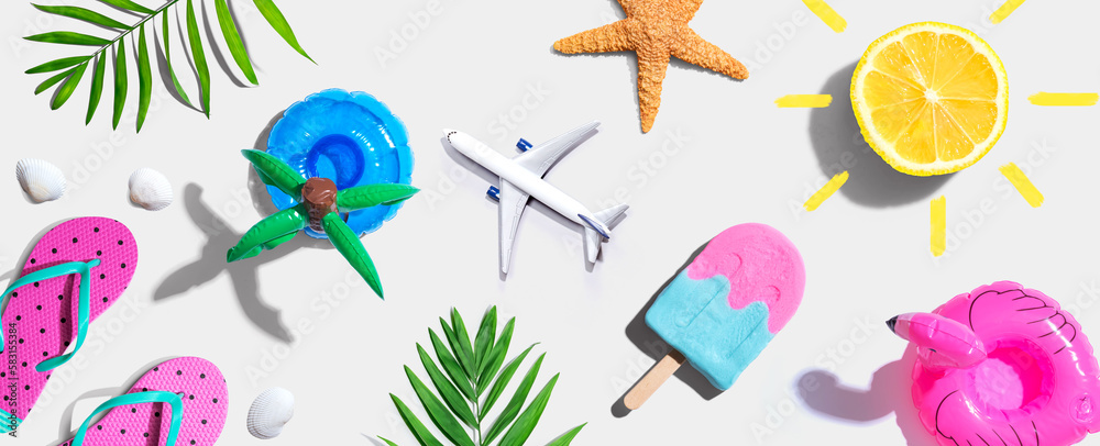 Summer concept with a airplane, a popsicle, flip flops and lemon sunshine - flat lay