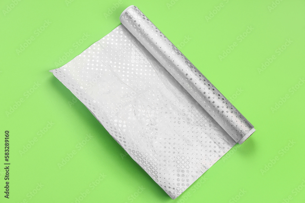 Roll of aluminium foil on green background