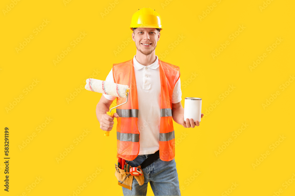 Male decorator on yellow background