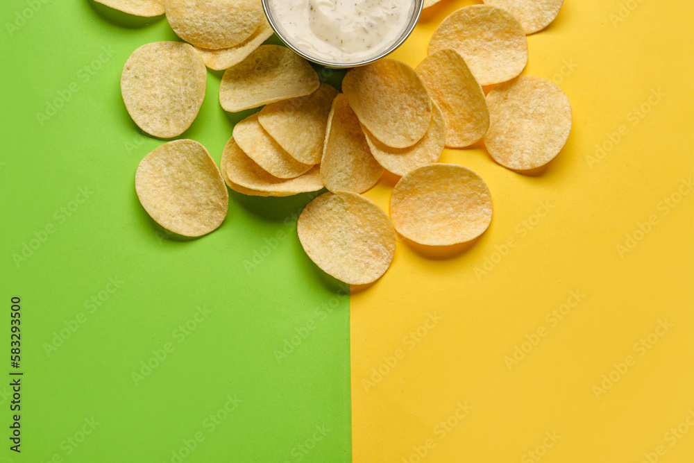 Bowl of sauce and delicious potato chips on green and yellow background