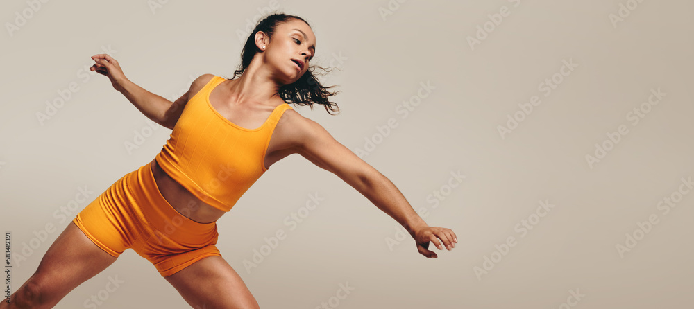 Active female working out in a studio, demonstrating her agility with her body movements