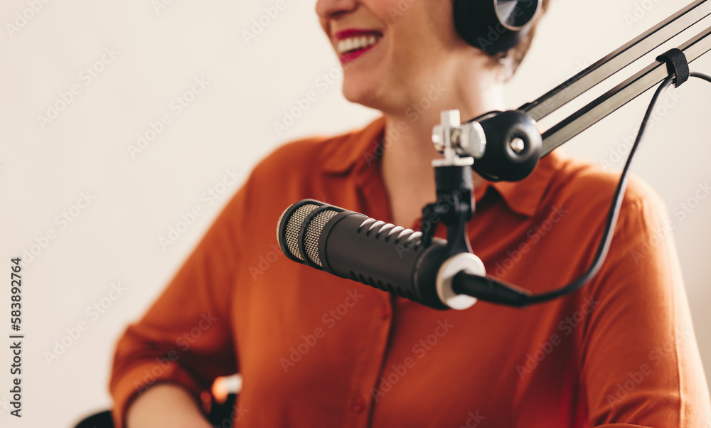 Happy woman hosting a radio show in a studio