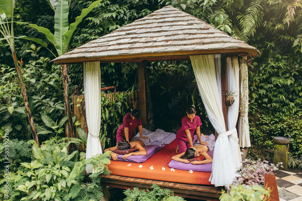 Couple receiving massage at outdoor spa