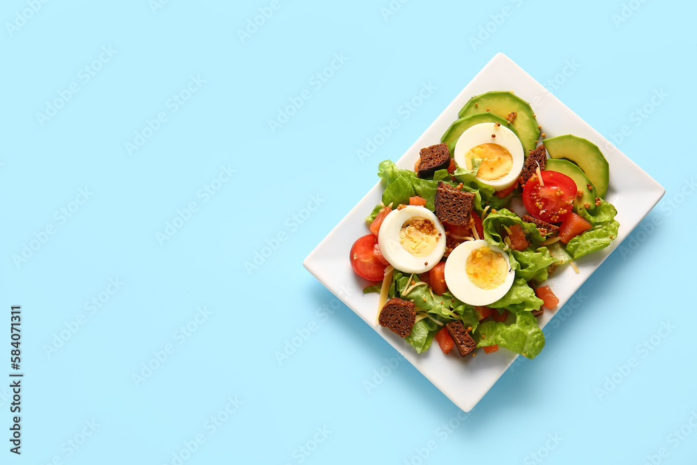 Plate of delicious salad with boiled eggs and salmon on blue background