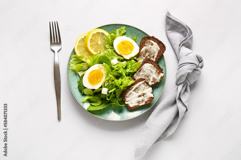 Plate of delicious salad with boiled eggs and cream cheese sandwiches on grey background