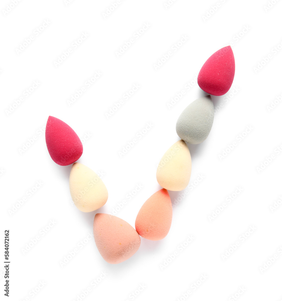 Check mark made of makeup sponges on white background