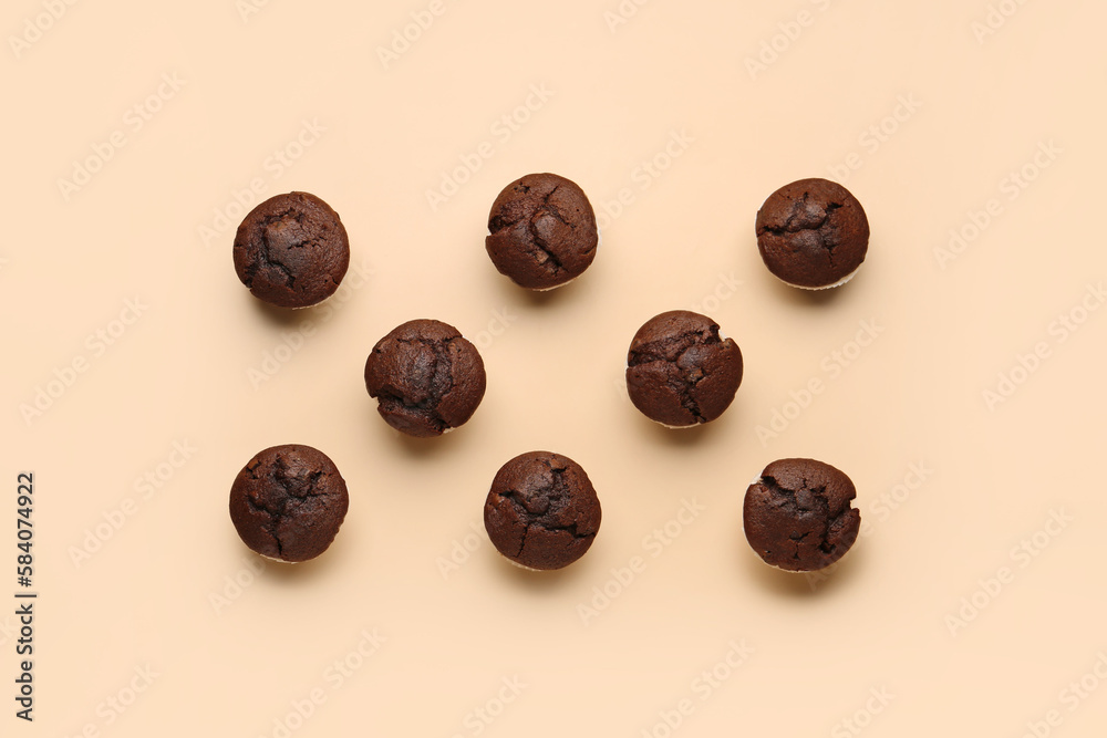 Tasty chocolate cupcakes on beige background