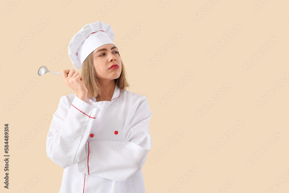 Thoughtful female chef with tablespoon on beige background