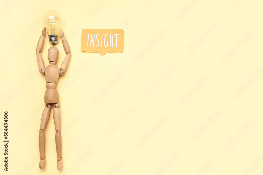 Wooden mannequin with light bulb and word INSIGHT on beige background