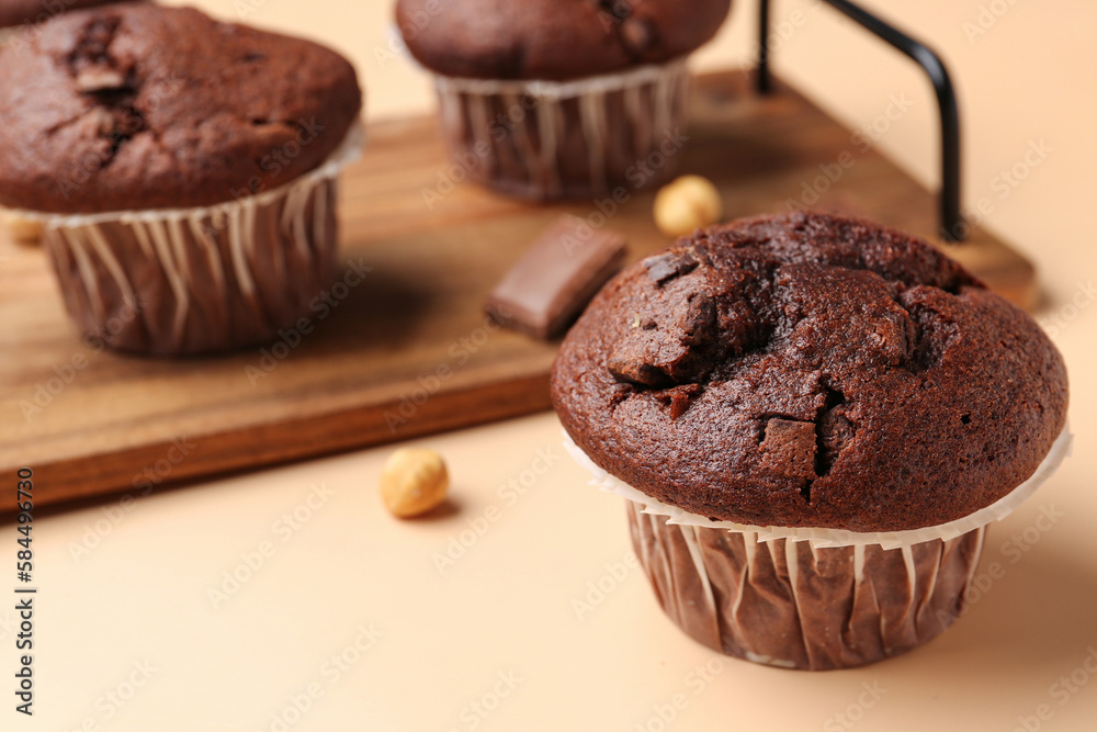 Tasty chocolate cupcakes on beige background