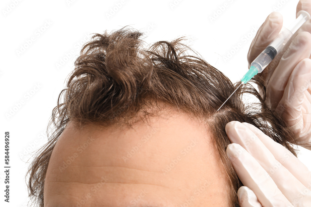 Young man receiving injection for hair growth on white background, closeup