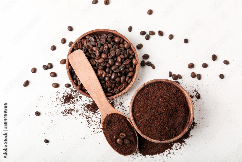 Spoon with bowls of coffee powder and beans on white background