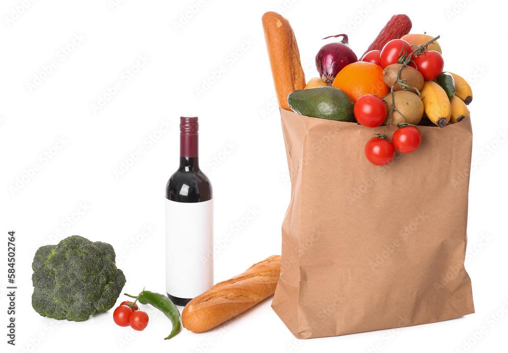 Paper bag with vegetables, fruits and wine bottle on white background