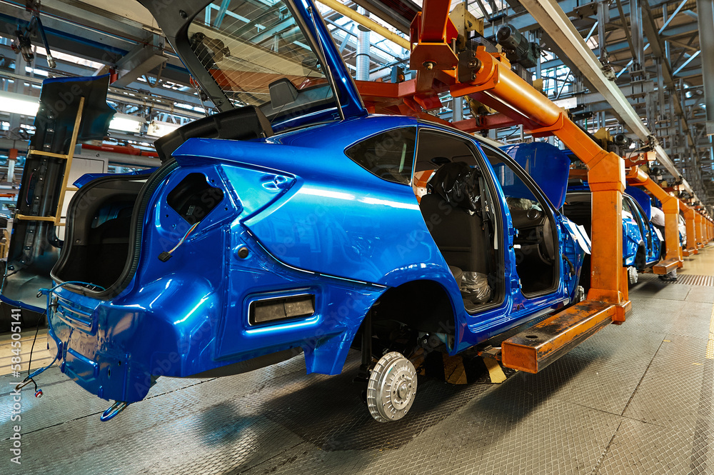 Bright blue modern cars bodies in assembling workshop