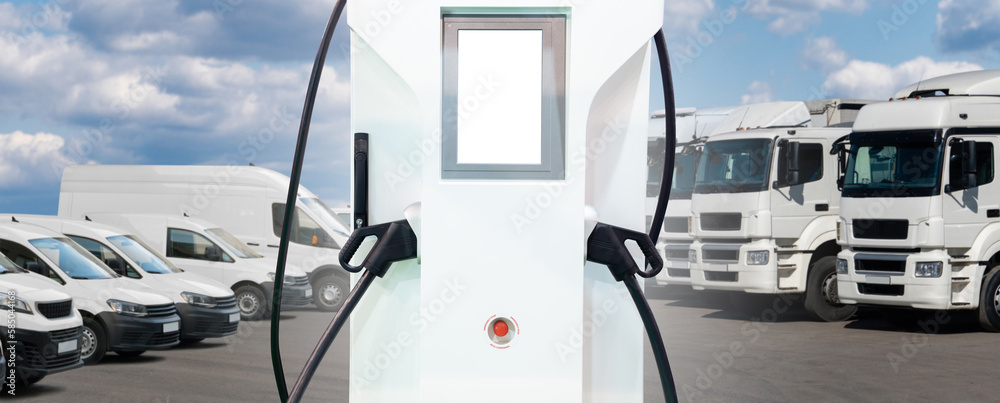 Electric vehicles charging station on a background of trucks and vans. Green fleet concept	