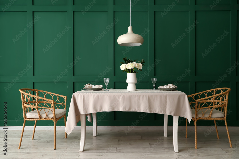 Vase with ranunculus flowers on dining table in room